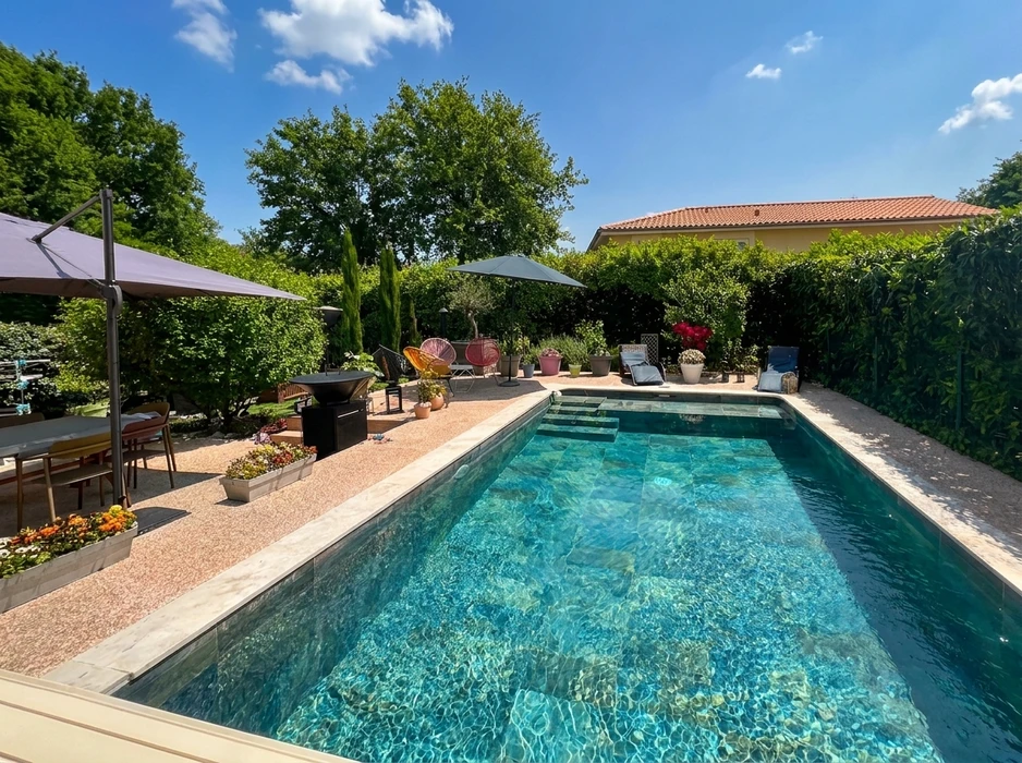 Piscine creusée rectangulaire avec margelles en béton, échelle métallique d'accès et eau turquoise claire