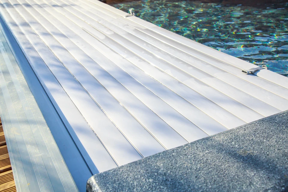 Piscine couverte d'une bâche bleue en hiver pour la protéger et éviter les risques