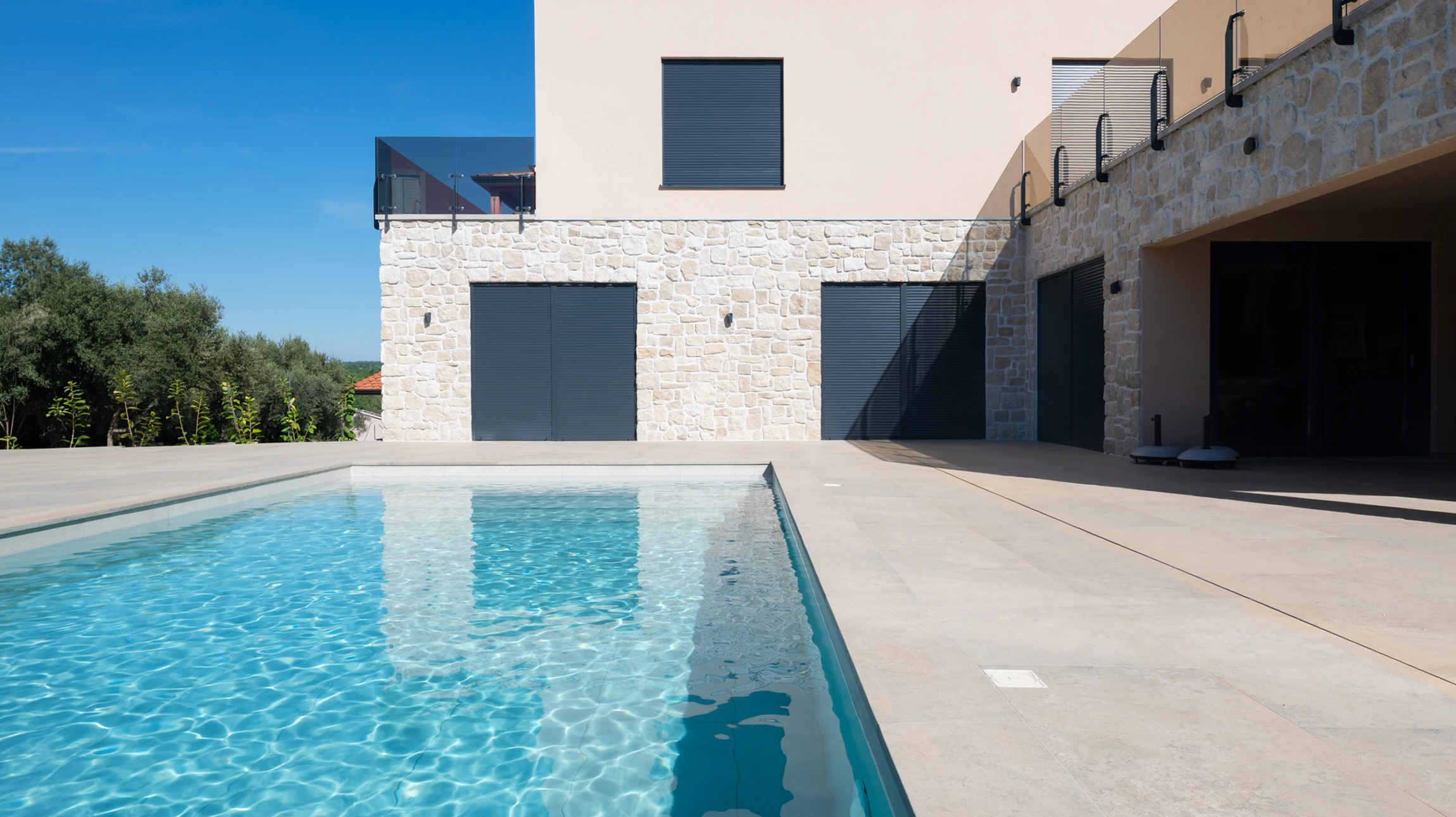 Piscine extérieure résidentielle avec un technicien nettoyant le bassin