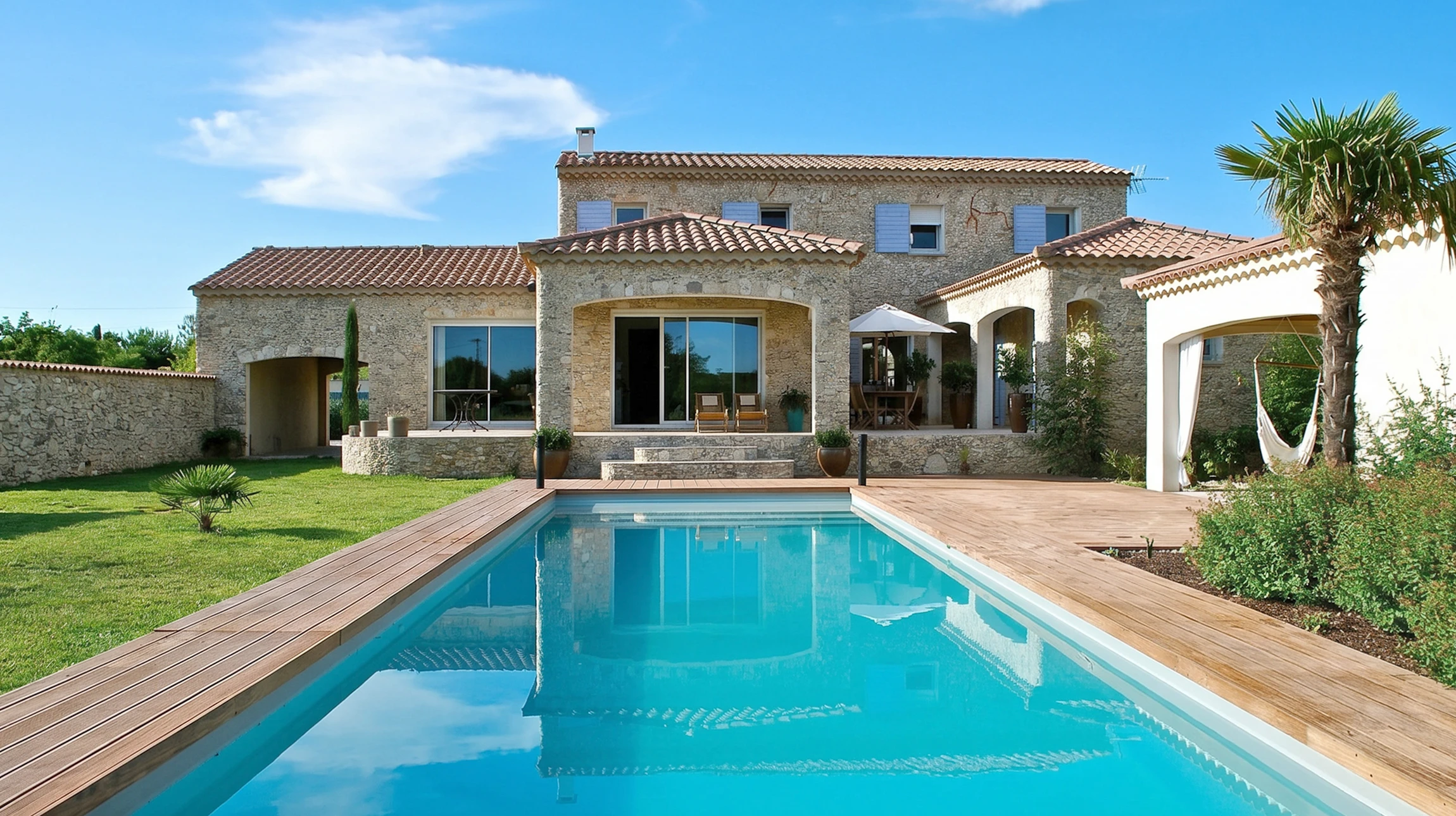 Extérieur piscine avec margelle en béton désactivé, bordure décorative en galets de rivière multicolores et revêtement carrelage bleu turquoise